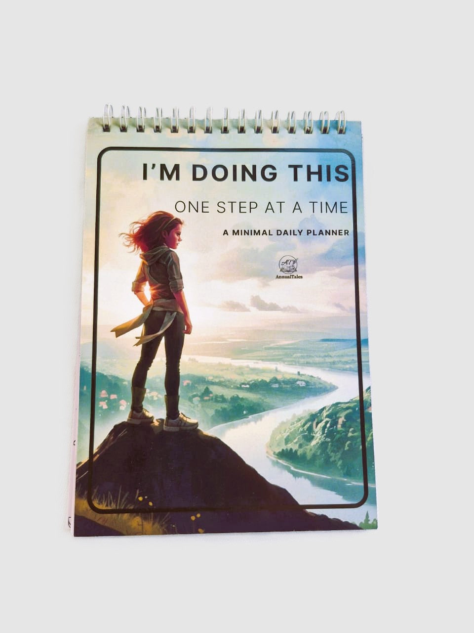 Planner with a scenic cover featuring a person on a mountain and text 'I'm doing this one step at a time'.